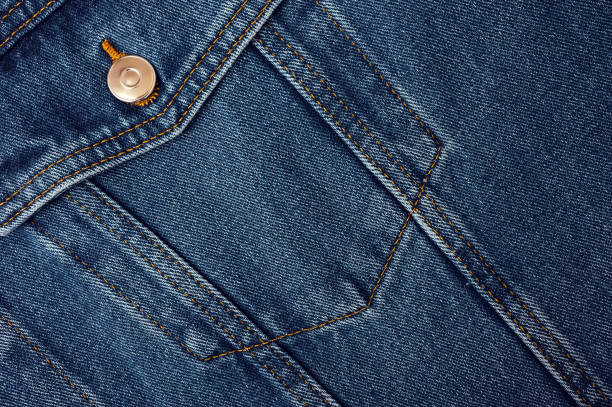 Close-up of a blue denim jacket pocket with detailed stitching and a metal button, ideal for stylish over-50 fashion.